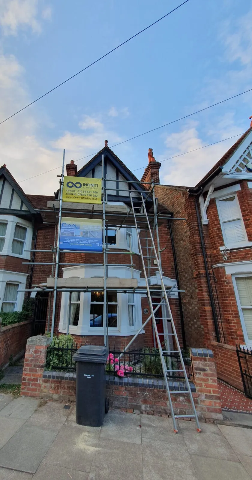 A house with a ladder up to it's roof.