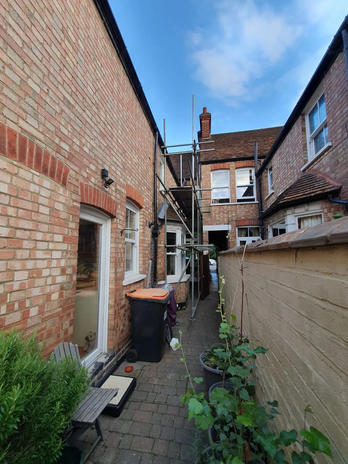 A brick building with a ladder up to it.