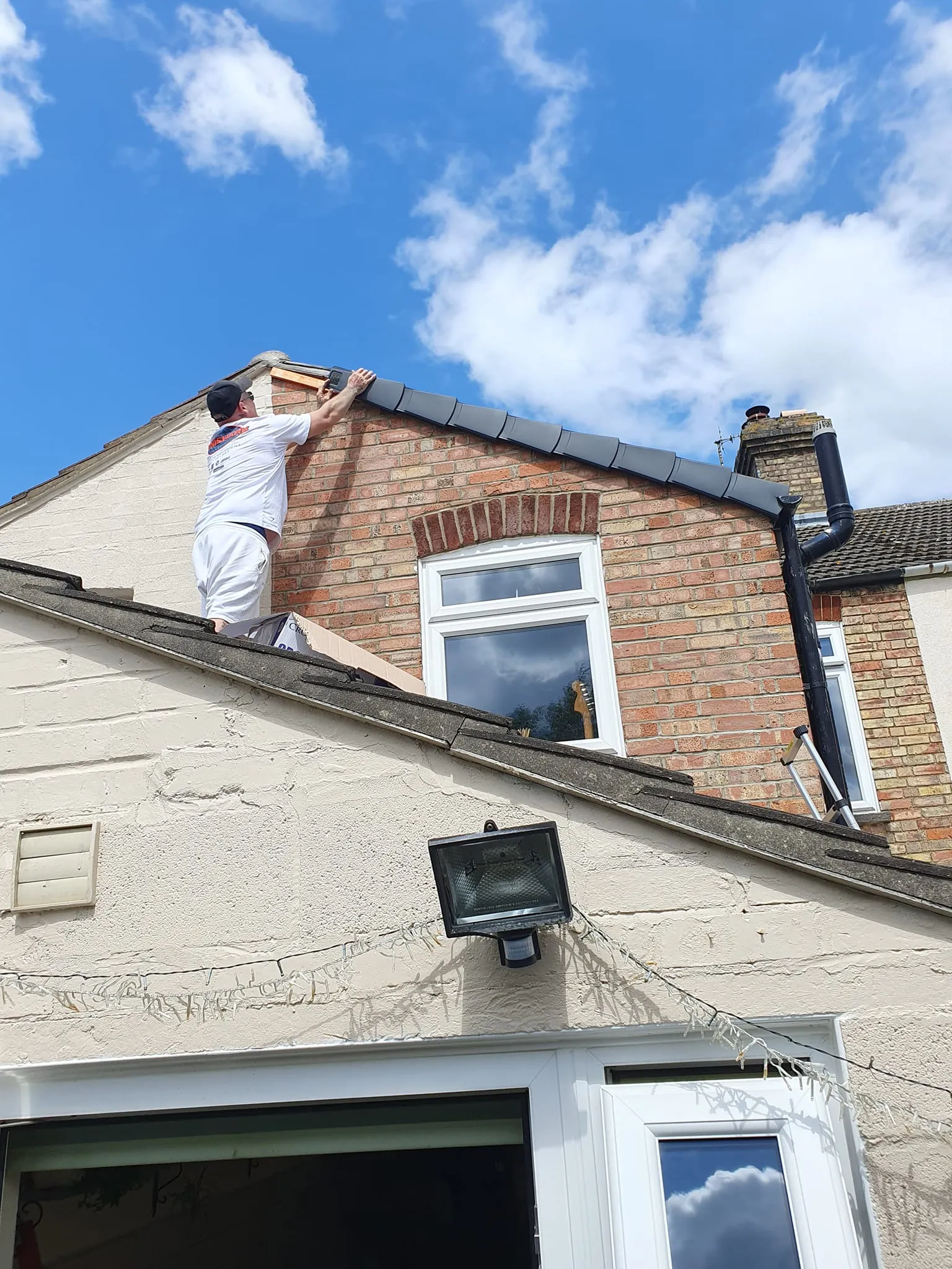 A man on a roof working on a house.